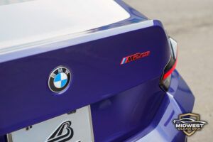 A purple BMW M2 CS with bronze M wheels and red brake calipers, after XPEL paint protection film, ceramic coating, and window tint installation at Midwest Clear Bra.