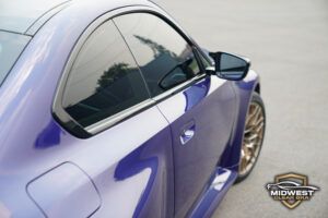 A purple BMW M2 CS with bronze M wheels and red brake calipers, after XPEL paint protection film, ceramic coating, and window tint installation at Midwest Clear Bra.