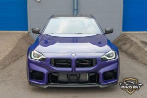 A purple BMW M2 CS with bronze M wheels and red brake calipers, after XPEL paint protection film, ceramic coating, and window tint installation at Midwest Clear Bra.